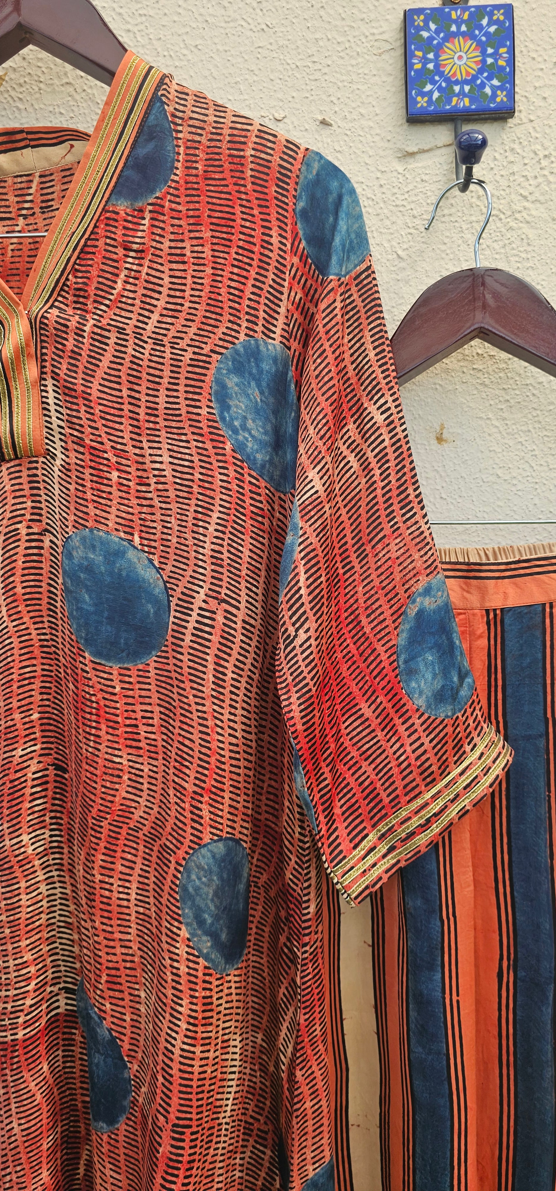 Modalsilk coordset with blue and red patterns on a wooden hanger against a neutral background